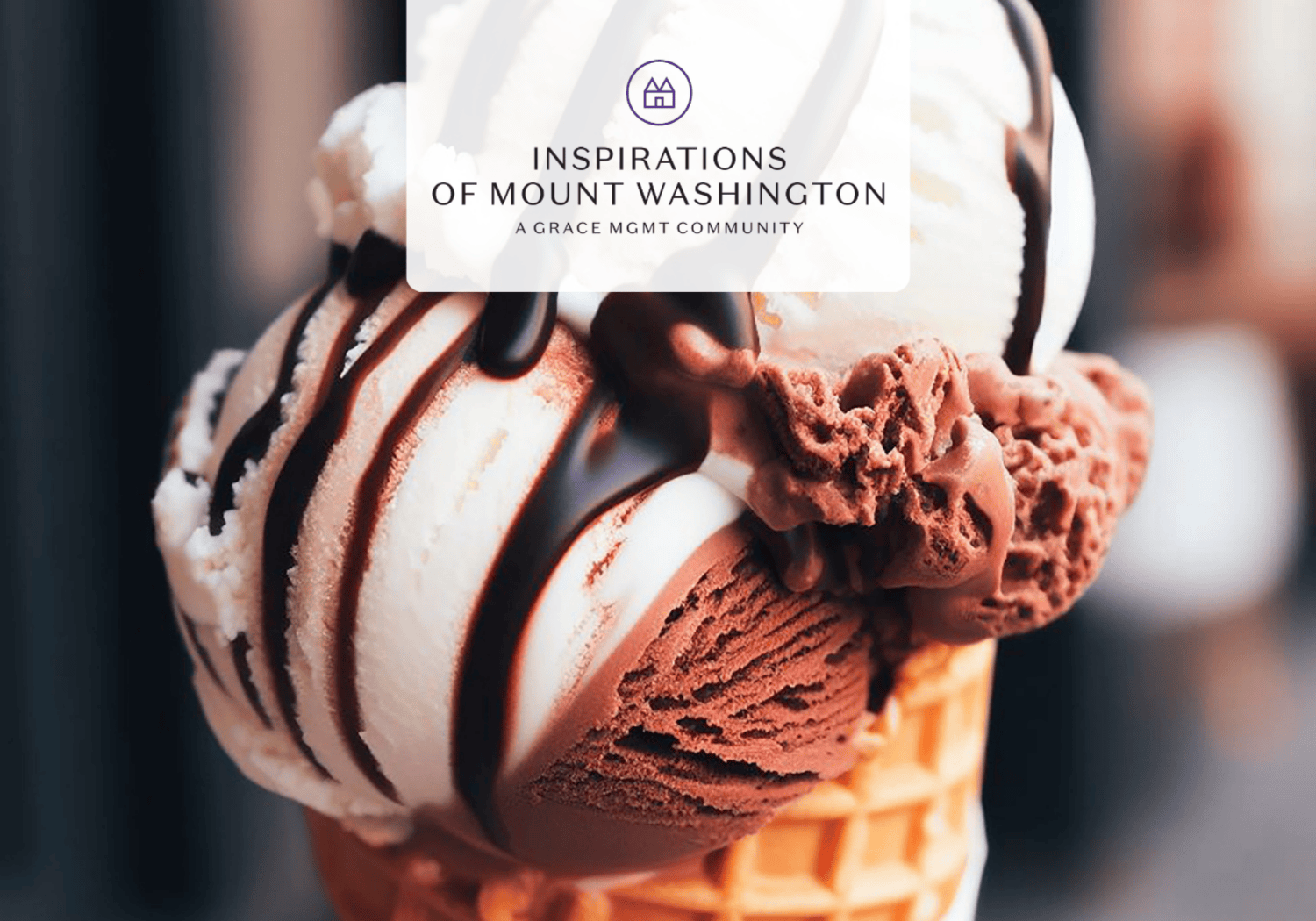 Close-up of a two-scoop ice cream cone (vanilla and chocolate) with chocolate drizzle, topped by a semi-transparent brand badge reading 'Inspirations of Mount Washington'.